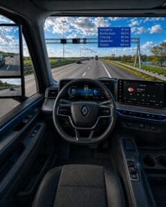 Bestuurdersperspectief vanuit een moderne elektrische Renault-truck op de Nederlandse snelweg, met een verkeersbord naar de vijf vestigingen van Sluyter Logistics.
